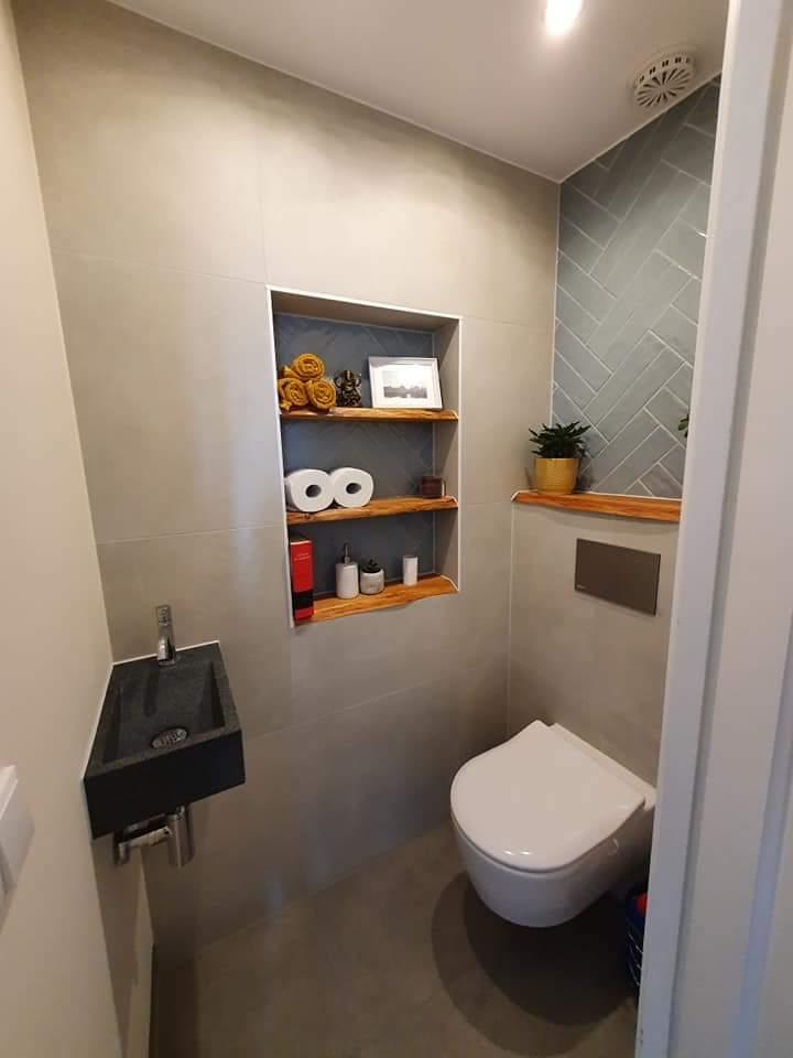Toiletruimte met wandcloset, natuurstenen fontein en visgraattegel in blauwgrijs