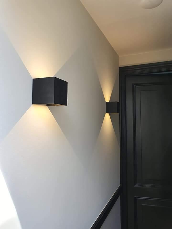 Wandverlichting met zwarte armaturen in de gang
