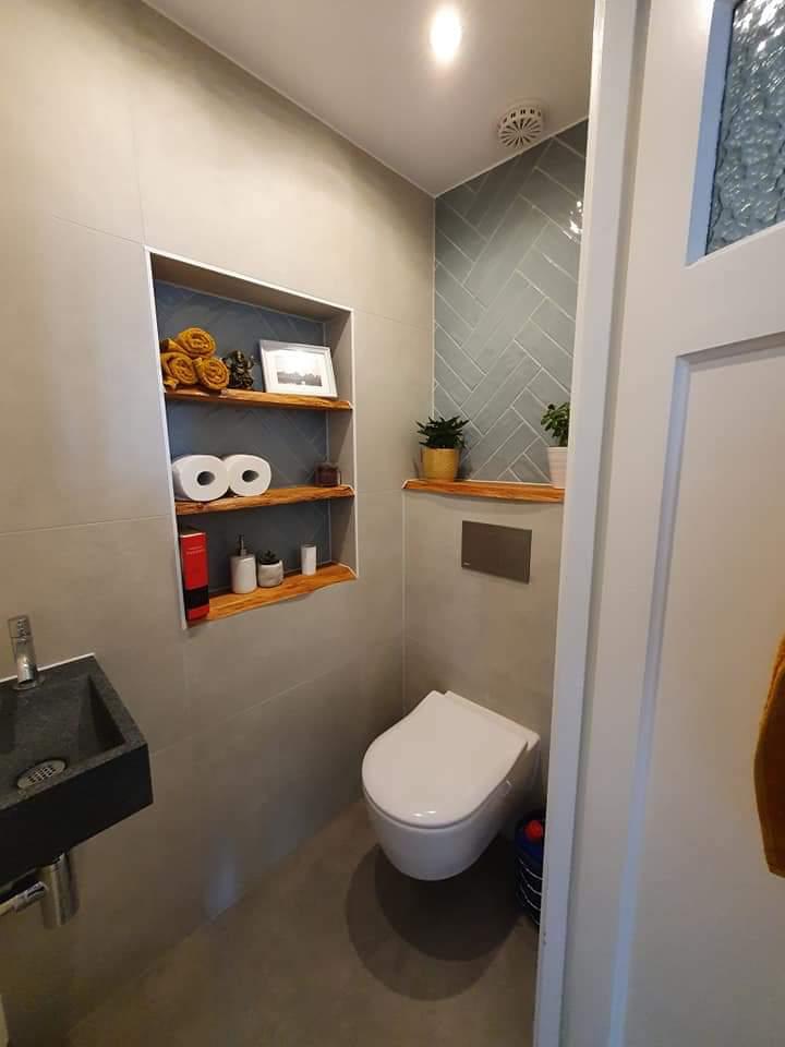 Toilet met verwarmd handdoekje, nis met planken en wandcloset